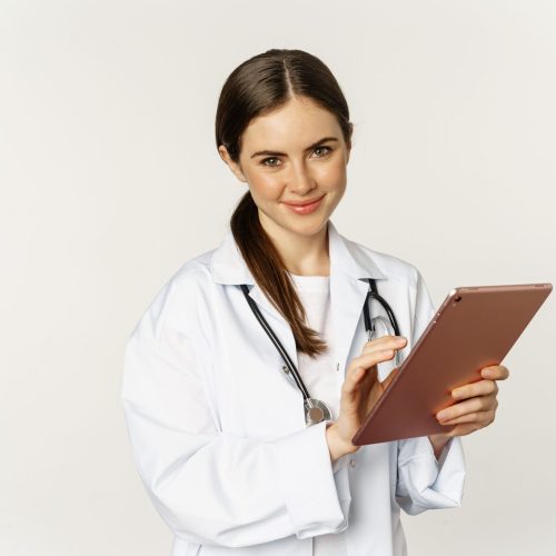 Doctor in white coat using digital tablet, reading medical data on gadget, working in hospital, standing over white background Doctor in white coat using digital tablet, reading medical data on gadget, working in hospital, standing over white background.